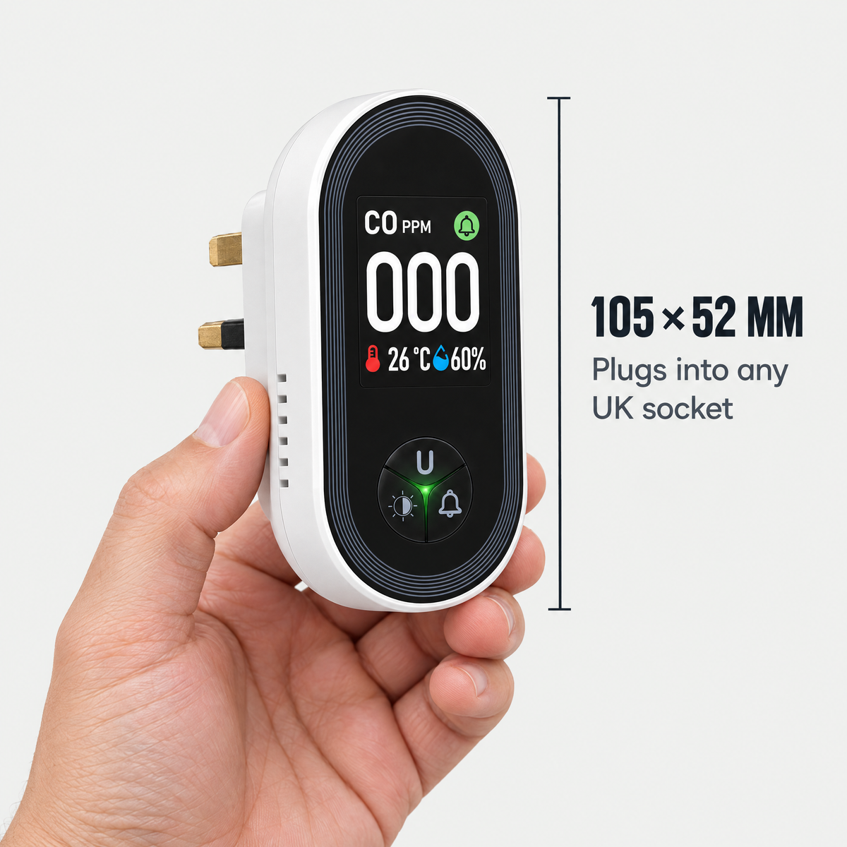 The monitor held in a hand, 105 by 52 mm, with a UK plug on the back